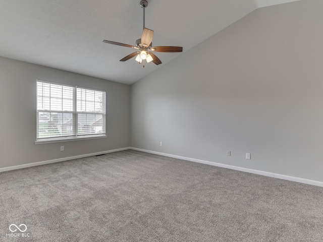 empty room featuring carpet flooring, a ceiling fan, baseboards, and lofted ceiling