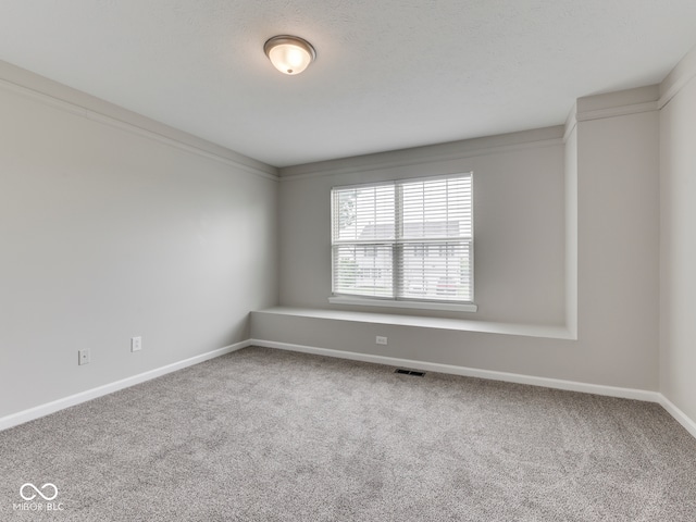 carpeted empty room featuring baseboards and visible vents