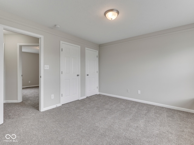 unfurnished bedroom featuring baseboards and carpet flooring
