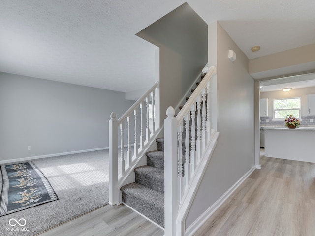 stairs with baseboards and wood finished floors