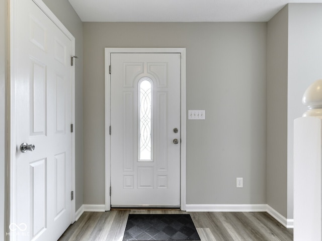 foyer featuring baseboards and wood finished floors