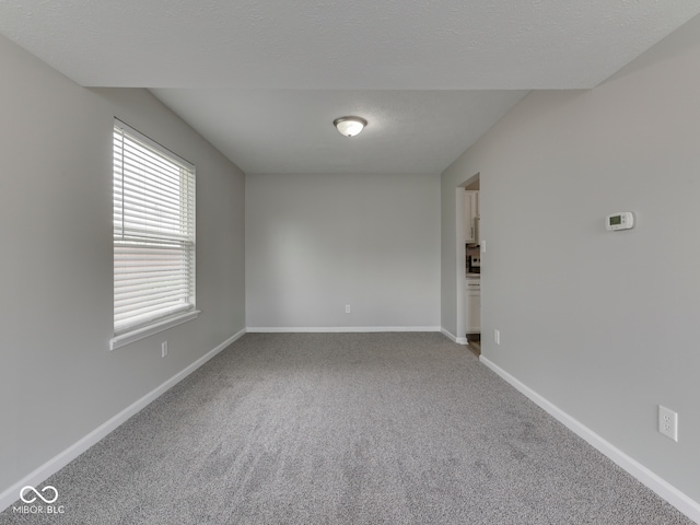 empty room with baseboards and carpet