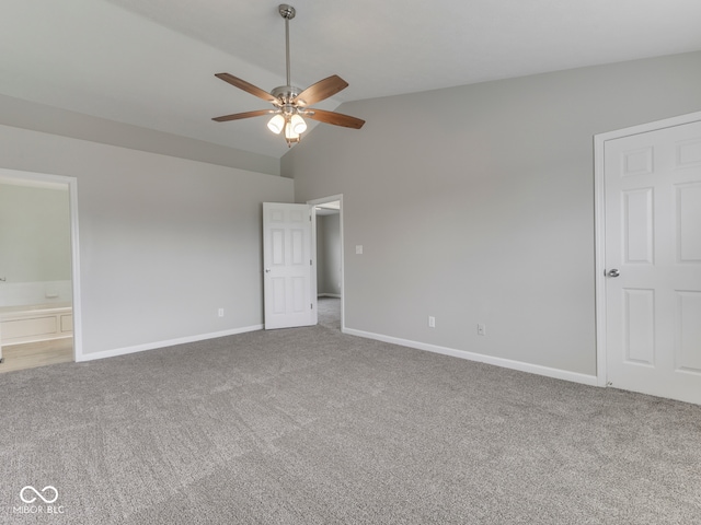 unfurnished bedroom with baseboards, carpet flooring, connected bathroom, and high vaulted ceiling