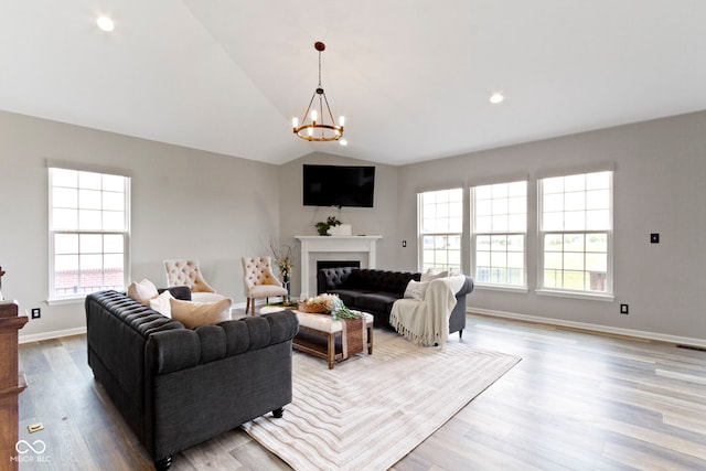 11595 Platt St, Noblesville, IN 46060 - living area featuring a chandelier, wood finished floors, vaulted ceiling, a fireplace, and baseboards