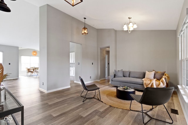 11595 Platt St, Noblesville, IN 46060 - living area featuring wood finished floors, a chandelier, plenty of natural light, a high ceiling, and baseboards