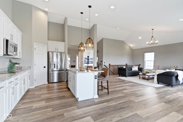 11595 Platt St, Noblesville, IN 46060 - kitchen with appliances with stainless steel finishes, open floor plan, a sink, a chandelier, and white cabinetry