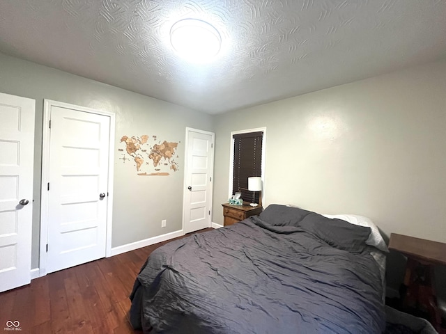 bedroom with dark wood-type flooring and baseboards