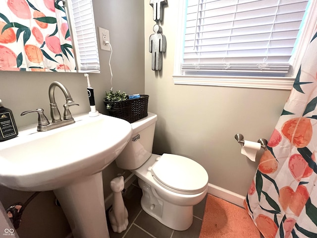 bathroom featuring toilet, a sink, and tile patterned flooring