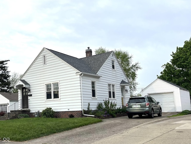 view of side of property featuring a shingled roof, a detached garage, an outdoor structure, and a chimney
