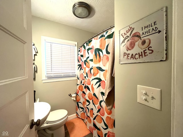 bathroom with a shower with curtain and toilet