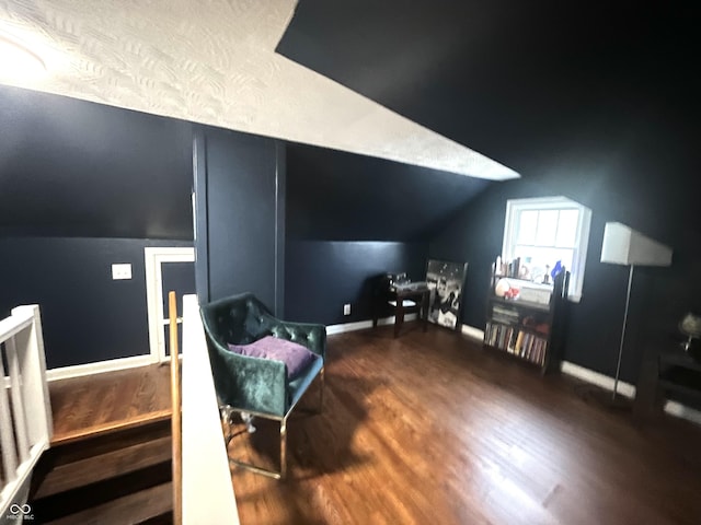 additional living space featuring baseboards, wood finished floors, and lofted ceiling