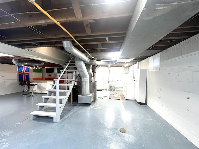 unfinished basement featuring heating unit and a sink