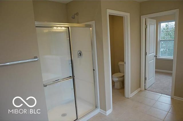 full bath with baseboards, tile patterned floors, toilet, and a shower stall