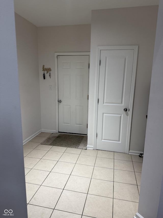 interior space featuring baseboards and light tile patterned floors
