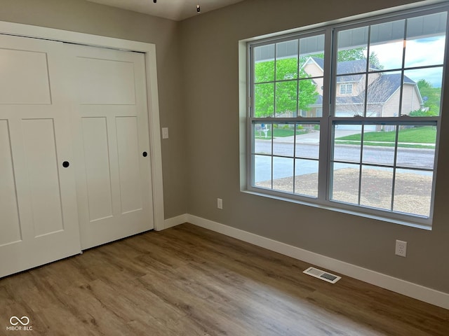 unfurnished bedroom with baseboards, multiple windows, and visible vents