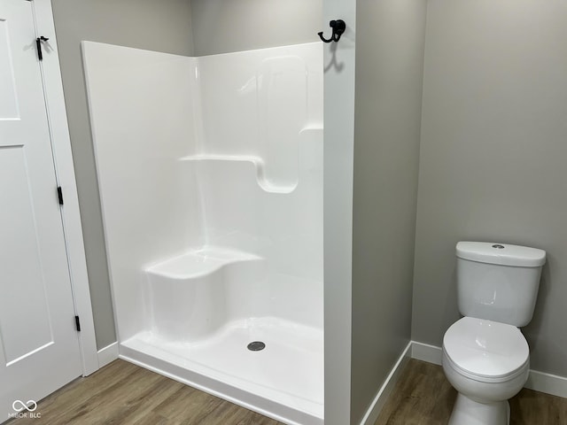bathroom featuring baseboards, walk in shower, and wood finished floors
