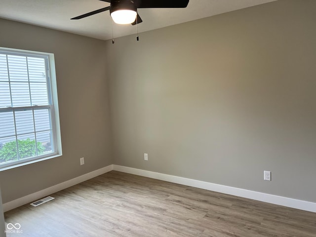 unfurnished room with baseboards, ceiling fan, wood finished floors, and visible vents