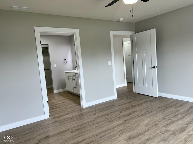 unfurnished bedroom featuring baseboards, visible vents, and wood finished floors