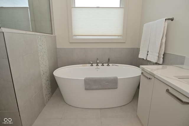full bathroom with tile walls, a walk in shower, tile patterned flooring, vanity, and a freestanding bath