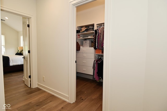 hall with baseboards and wood finished floors