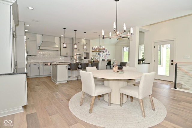 dining room with recessed lighting, light wood-style floors, and a notable chandelier