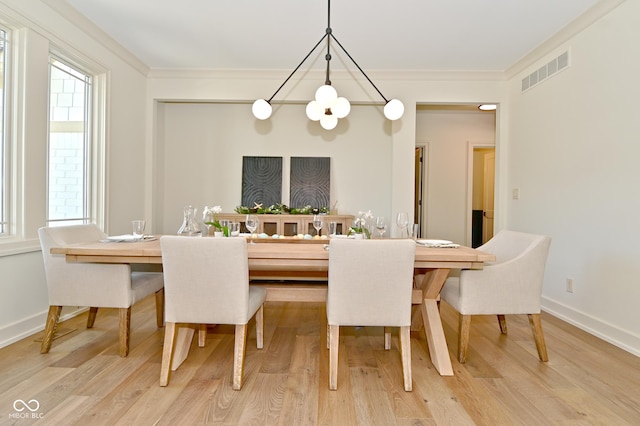 dining space featuring ornamental molding, visible vents, and wood finished floors