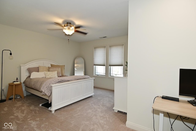bedroom featuring baseboards, visible vents, a ceiling fan, and light colored carpet