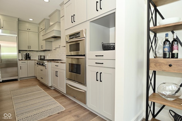 kitchen featuring light wood-style flooring, recessed lighting, decorative backsplash, a warming drawer, and stainless steel appliances