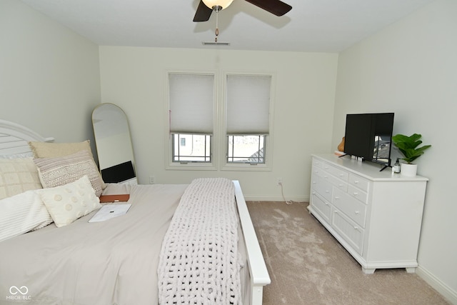 bedroom featuring light carpet, baseboards, and a ceiling fan