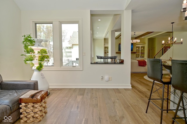 interior space with a chandelier, wood finished floors, and a healthy amount of sunlight