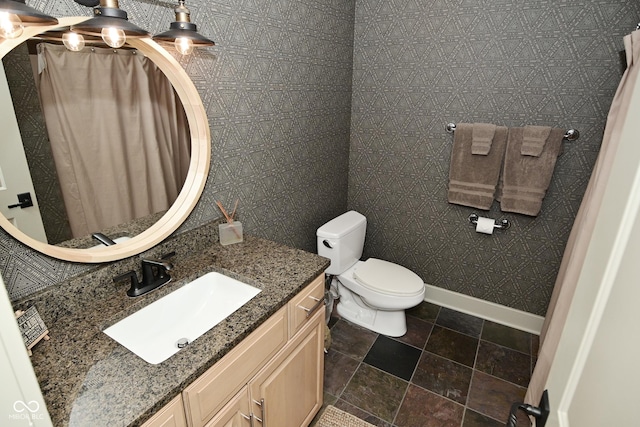 full bathroom featuring baseboards, vanity, toilet, and stone finish floor