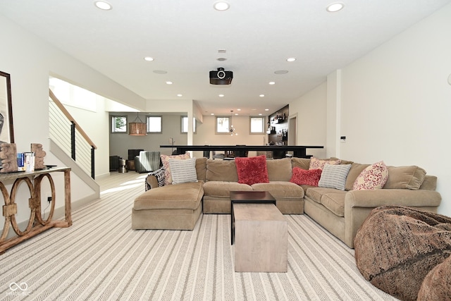living area featuring stairs, light carpet, and recessed lighting