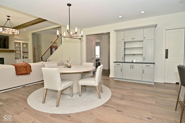 dining space featuring recessed lighting, light wood-type flooring, and a notable chandelier