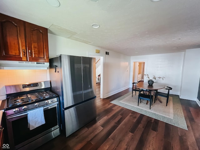 kitchen featuring baseboards, stainless steel appliances, dark wood finished floors, and under cabinet range hood