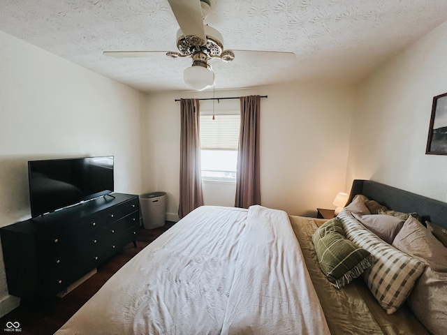 bedroom featuring baseboards, a textured ceiling, ceiling fan, and wood finished floors
