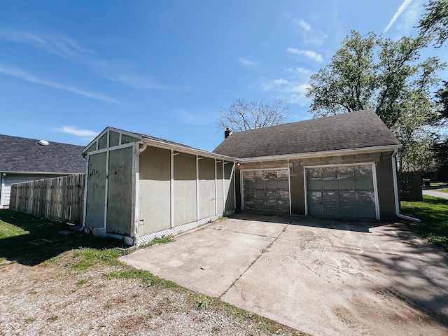 garage with fence and driveway