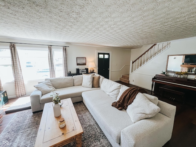 living room featuring stairs, ornamental molding, and wood finished floors