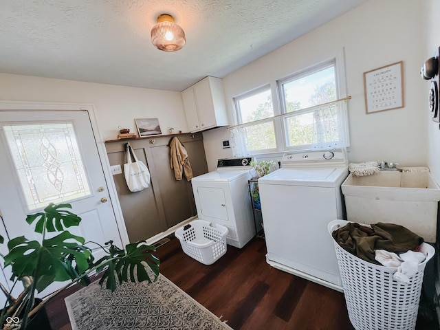 laundry area with a textured ceiling, washing machine and dryer, dark wood finished floors, cabinet space, and a sink