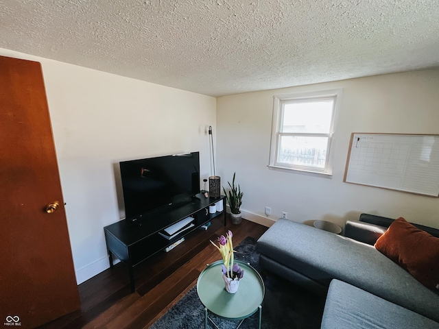 living room featuring baseboards, a textured ceiling, and wood finished floors