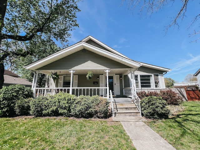 bungalow with covered porch and a front lawn