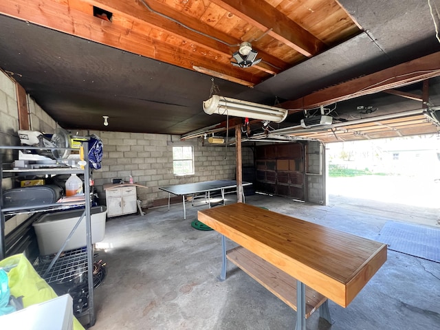 interior space featuring concrete block wall and a garage door opener