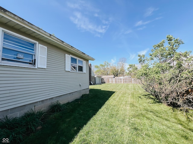 view of yard featuring central AC unit and fence