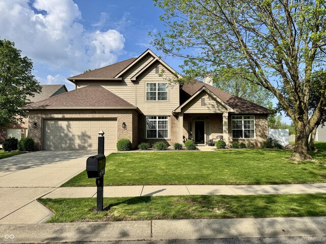 traditional-style home featuring brick siding, an attached garage, driveway, and a front yard