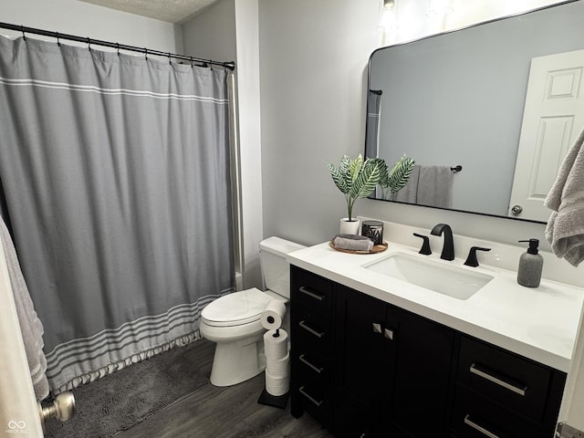 bathroom featuring a shower with curtain, a textured ceiling, wood finished floors, vanity, and toilet
