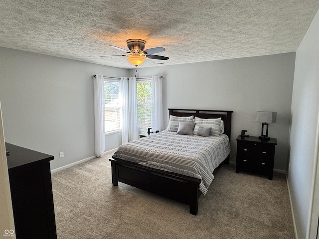 bedroom featuring carpet floors, a textured ceiling, baseboards, and ceiling fan