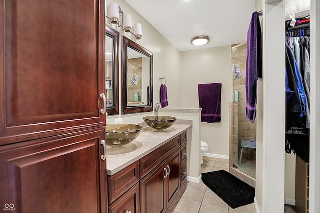 601 Shady Ln, Greenwood, IN 46142 - bathroom with double vanity, toilet, tile patterned floors, a sink, and a stall shower
