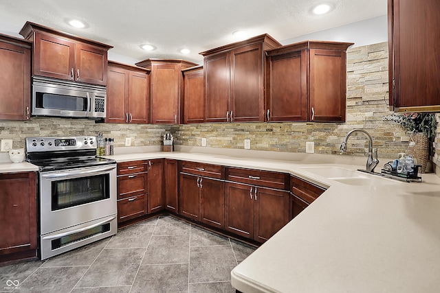 601 Shady Ln, Greenwood, IN 46142 - kitchen featuring backsplash, stainless steel appliances, a sink, and light countertops