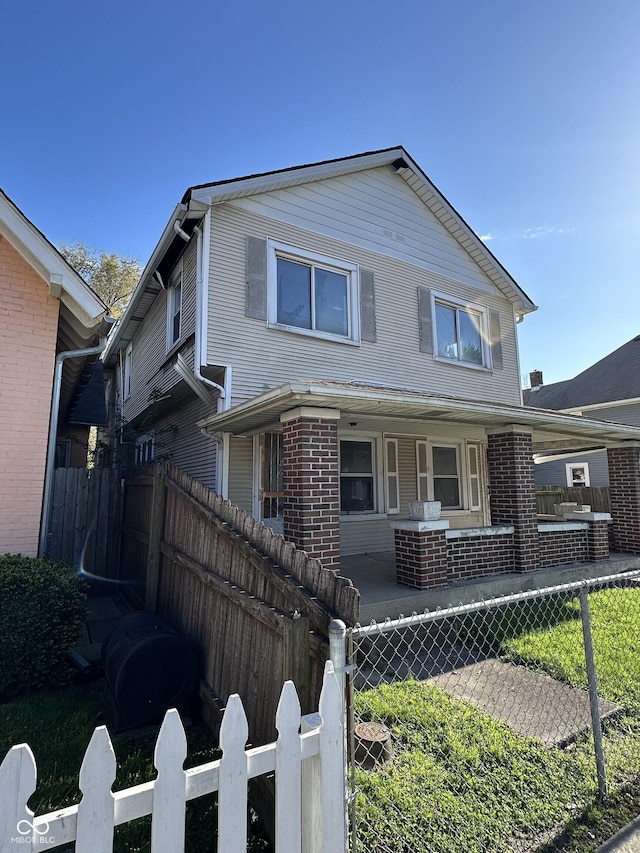 view of front of home featuring covered porch, fence private yard, and brick siding