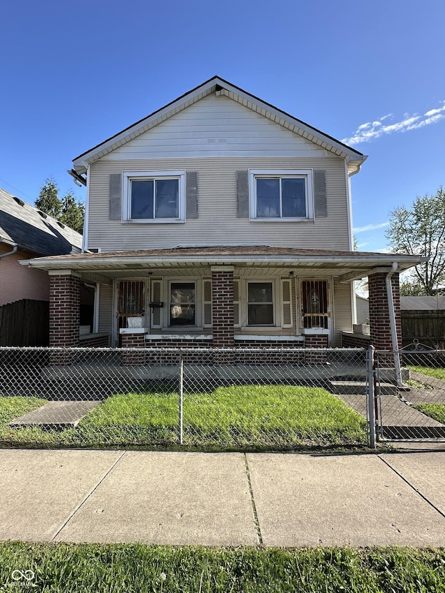 view of front of property with a gate, covered porch, a fenced front yard, and brick siding