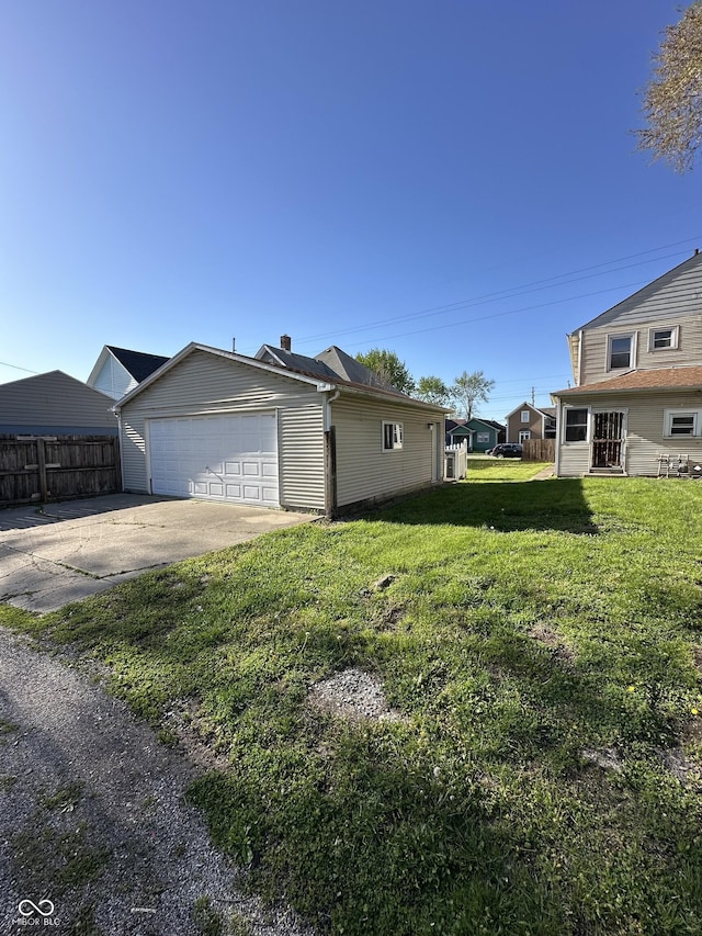 view of home's exterior featuring a lawn, fence, and driveway